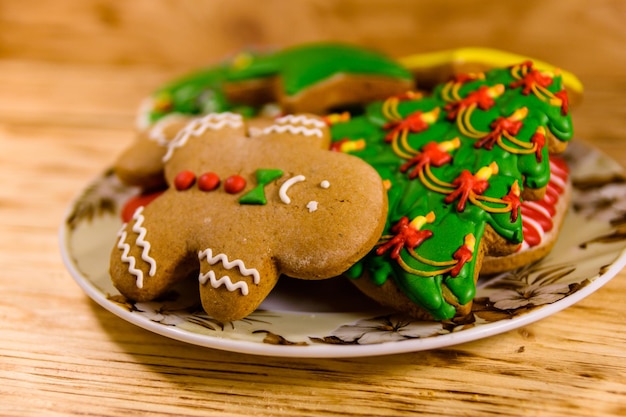 Assiette avec différents biscuits de pain d'épice de Noël sur une table en bois rustique