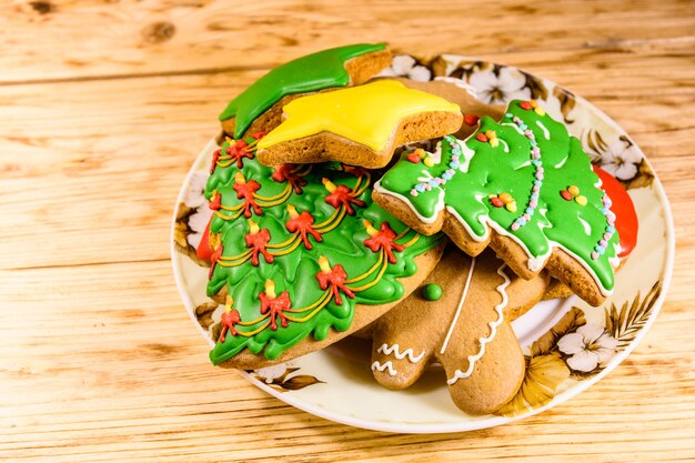 Assiette avec différents biscuits de pain d'épice de Noël sur une table en bois rustique