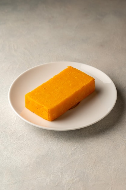 Une assiette d'éponge de curcuma jaune sur une assiette blanche.