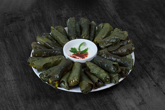 Photo une assiette de feuilles vertes avec un bol de sauce dessus