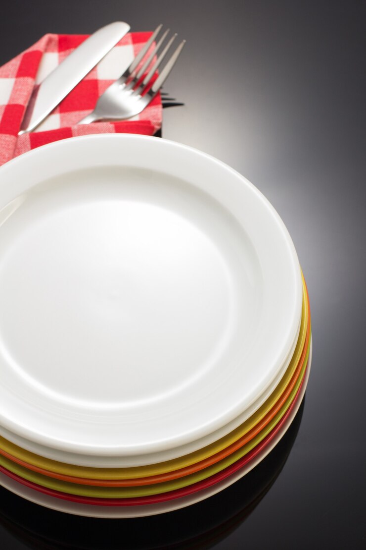 Assiette et fourchette avec couteau en serviette sur fond noir