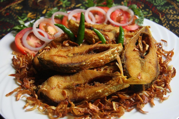 Une assiette de frites de poisson ilish avec oignon frit