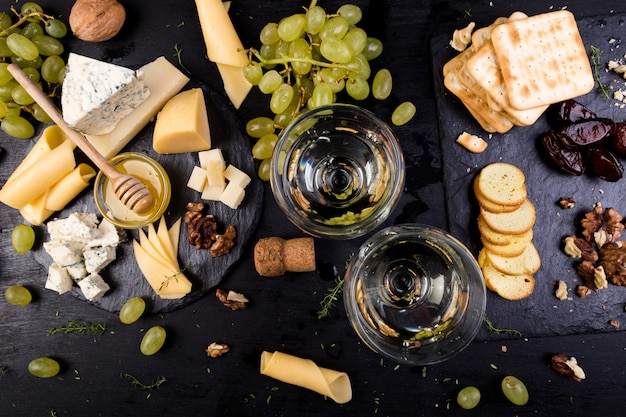 Assiette de fromage. Assortiment de fromages aux noix, pain et miel sur plaque d'ardoise en pierre.