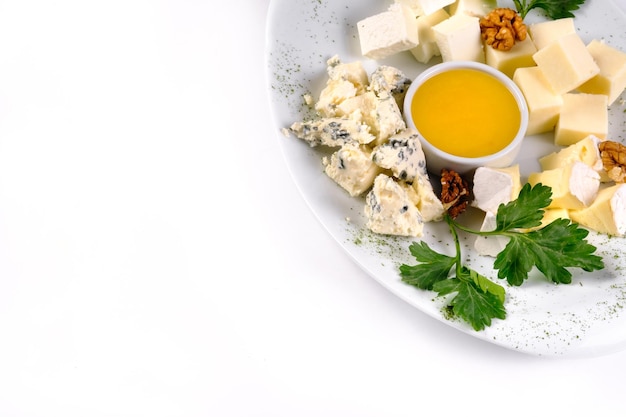 Assiette de fromages au miel sur fond blanc isolé