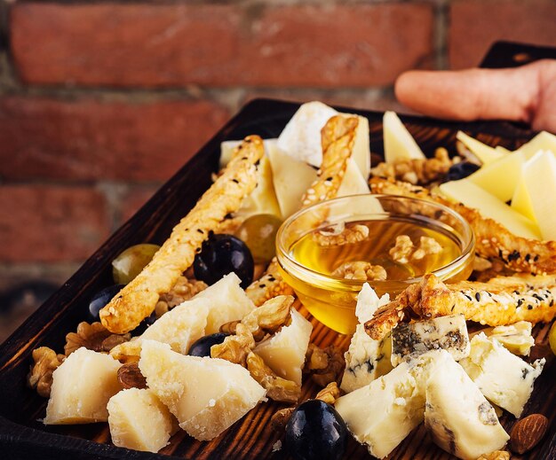 Assiette de fromages au miel, raisins et noix