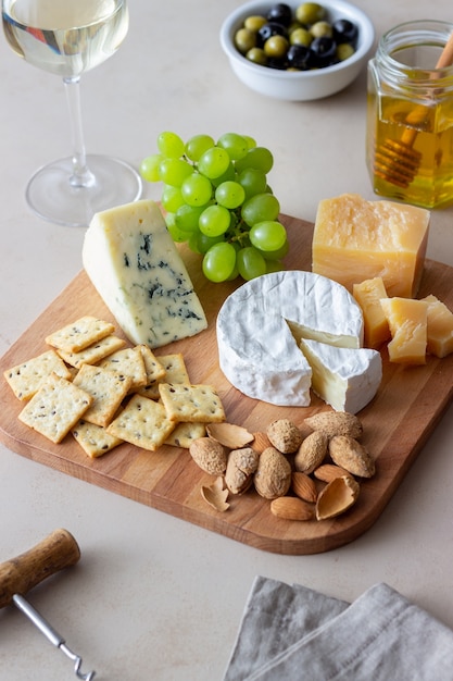 Assiette de fromages avec cracker, amandes et raisins. Apéritif au vin. Collation au vin.