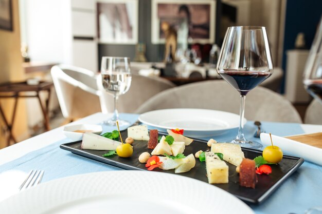 Assiette de fromages espagnols assortis avec du vin rouge sur la table bleue