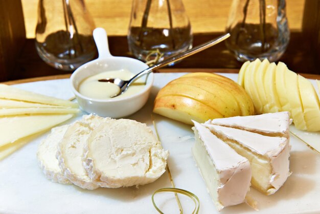 Assiette de fromages avec pomme camembert buche et miel sur table