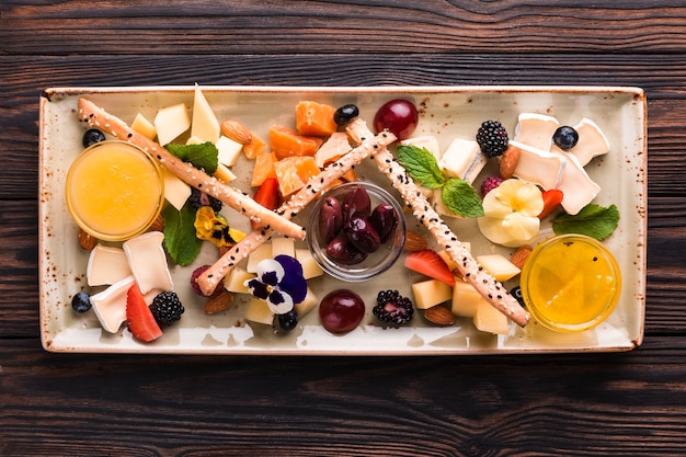 Assiette de fromages servie avec raisins et noix.