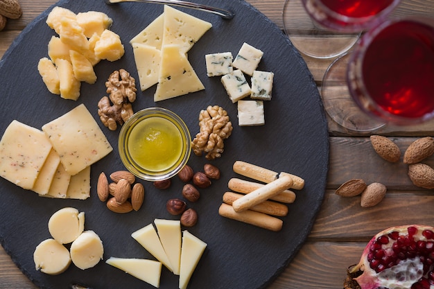 Assiette de fromages vue de dessus Assortiment de différents types de fromages sur planche à découper en ardoise foncée