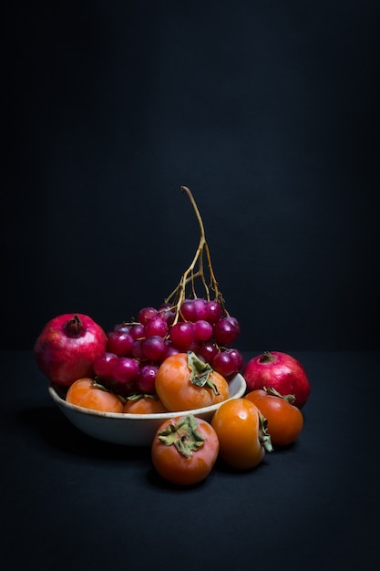 Photo une assiette de fruits d'automne sur fond noir