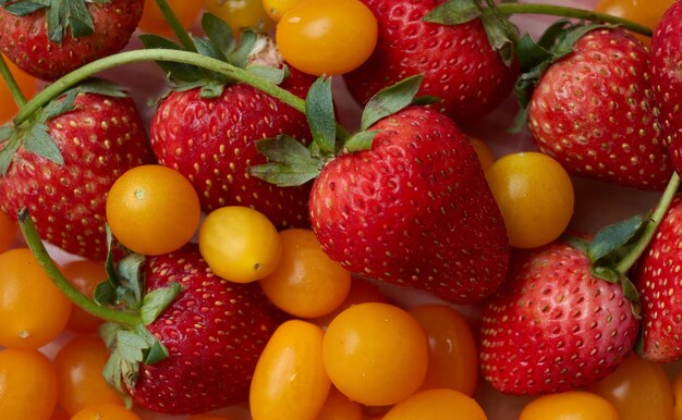 Une assiette de fruits avec une fraise et une cerise jaune.