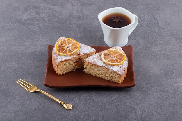 Assiette de gâteau maison aux citrons et tasse de thé sur la table.