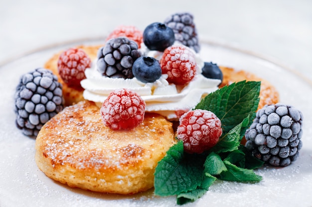 une assiette avec des gâteaux au fromage et des baies