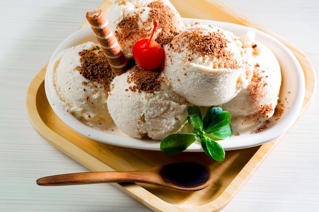 Une assiette de glace avec une cerise sur le dessus