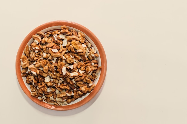 Assiette avec grains de noix sur fond beige