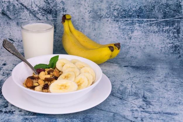 Assiette avec granola à la banane et au lait sur la table Espace de copie