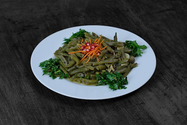 Photo une assiette de haricots verts avec une fleur rouge dessus