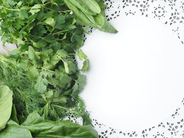 Une assiette d'herbes fraîches et une assiette blanche avec une bordure blanche.