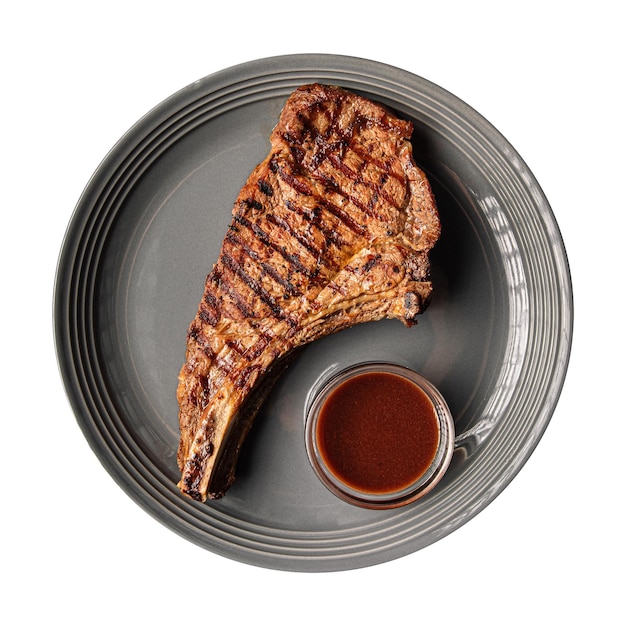 Assiette isolée d'os de steak de boeuf grillé