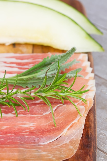 Assiette de jambon de porc salé espagnol close up avec melon et romarin