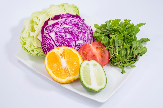 Une assiette de légumes et de citron vert et de citron frais.