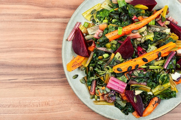 Une assiette de légumes avec un fond en bois