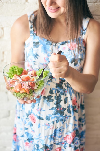 Assiette avec des légumes frais dans les mains de la femme enceinte