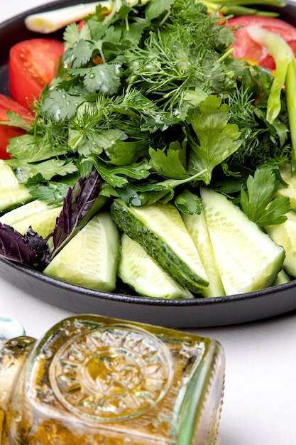 Assiette avec des légumes frais hachés et des herbes.