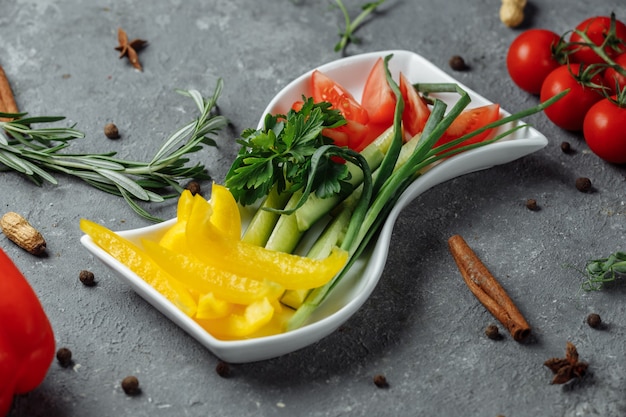 Assiette de légumes avec poivrons, concombres et tomates.