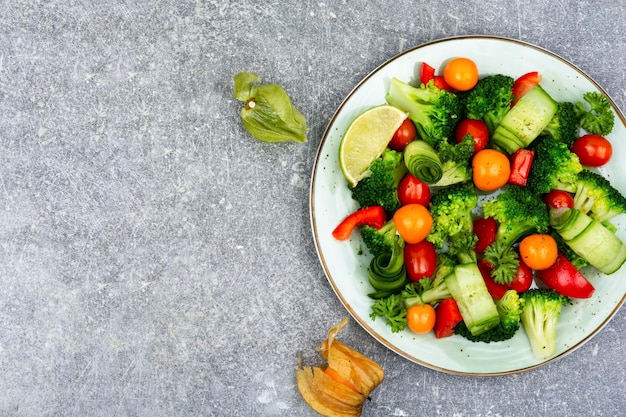 Une assiette de légumes avec un quartier de citron à côté