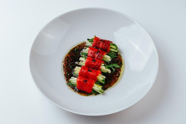 Une assiette de légumes avec une sauce rouge sur le dessus.