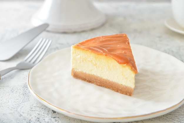 Assiette avec morceau de délicieux cheesecake sur table