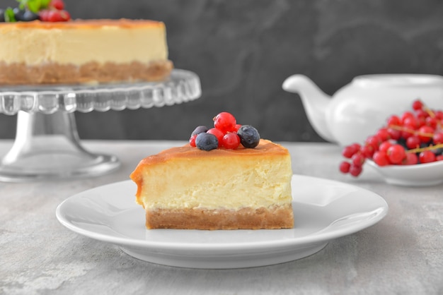 Assiette avec morceau de délicieux cheesecake sur table