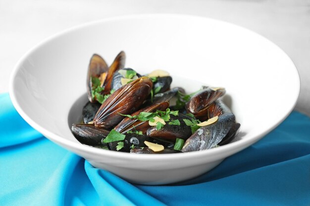 Assiette de moules à l'ail et au persil sur une serviette bleue