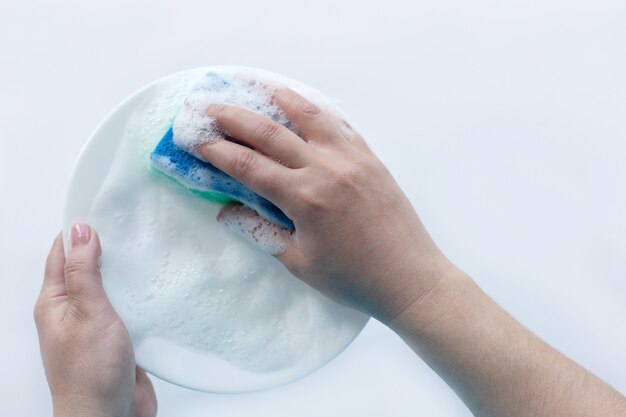 L'assiette en mousse à la main, laver la vaisselle