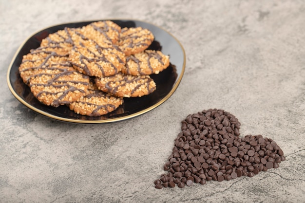 Assiette noire de biscuits à l'avoine et déposer le chocolat sur la table en pierre.