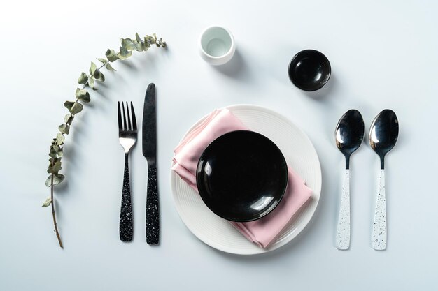 Assiette noire et blanche vide avec une cuillère moderne sur la maquette de la vue de dessus de fond blanc