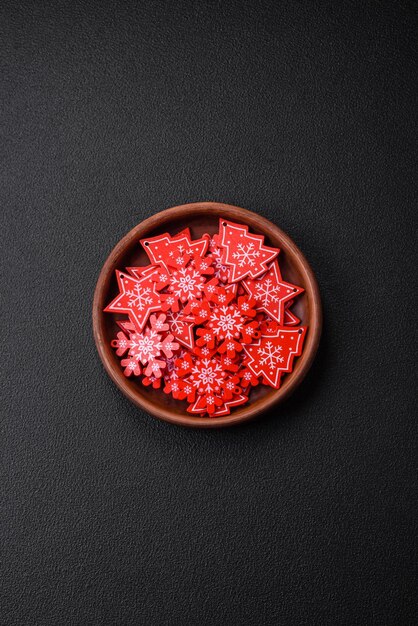 Assiette noire en céramique vide avec éléments de décoration de Noël sur fond de béton texturé de vacances