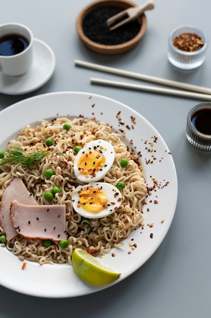 Photo assiette de nouilles au jambon, œuf à la coque et tranche de citron