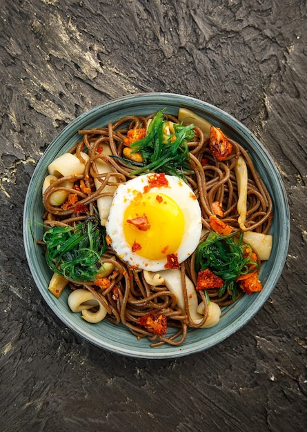 Assiette avec nouilles de sarrasin de cuisine asiatique avec champignons aux œufs et légumes