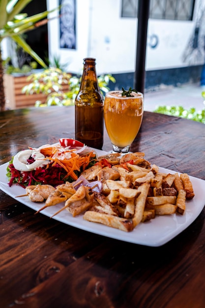 Une assiette de nourriture accompagnée d'un cocktail et d'une bouteille