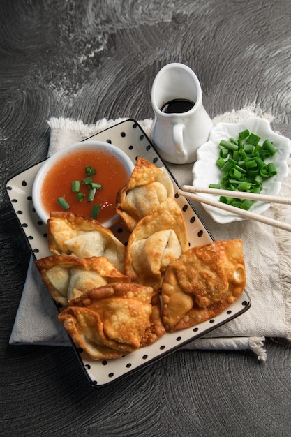 Une assiette de nourriture avec des baguettes et un bol de sauce