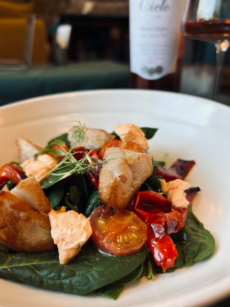 Une assiette de nourriture avec une bouteille de vin derrière.