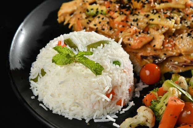 Une assiette de nourriture avec du riz, des légumes et une salade