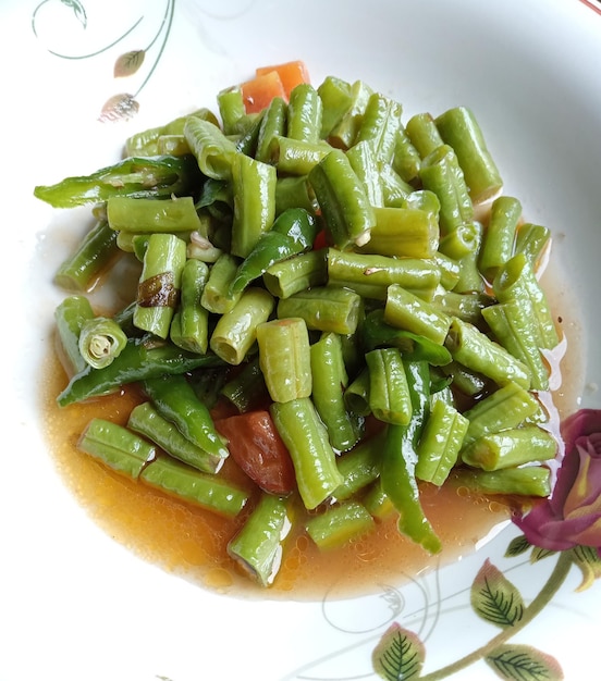 une assiette de nourriture avec une image de haricots verts et de carottes