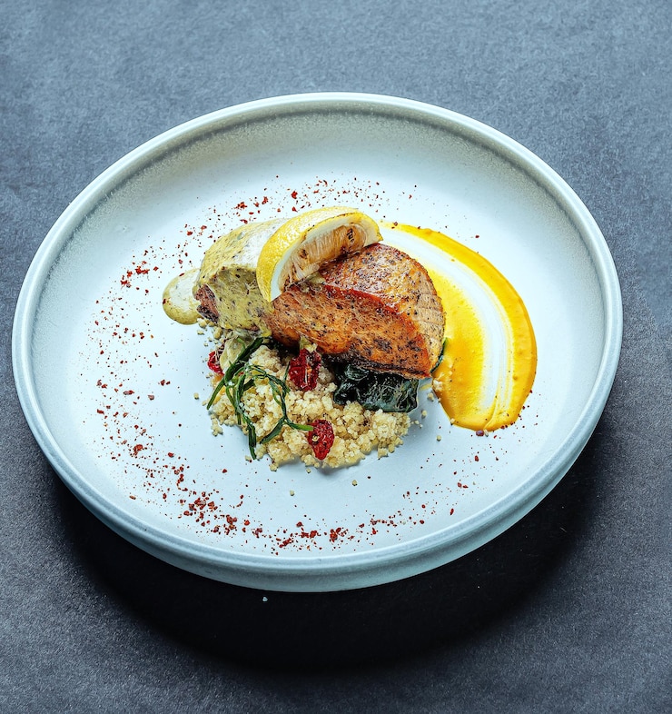 Photo une assiette de nourriture avec un morceau de poisson dessus et un morceaux de nourriture dessus