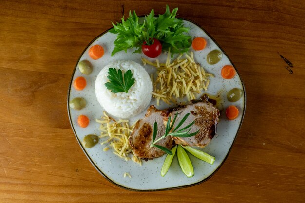 assiette de nourriture riz viande salade et pommes de terre sur une assiette repas complet