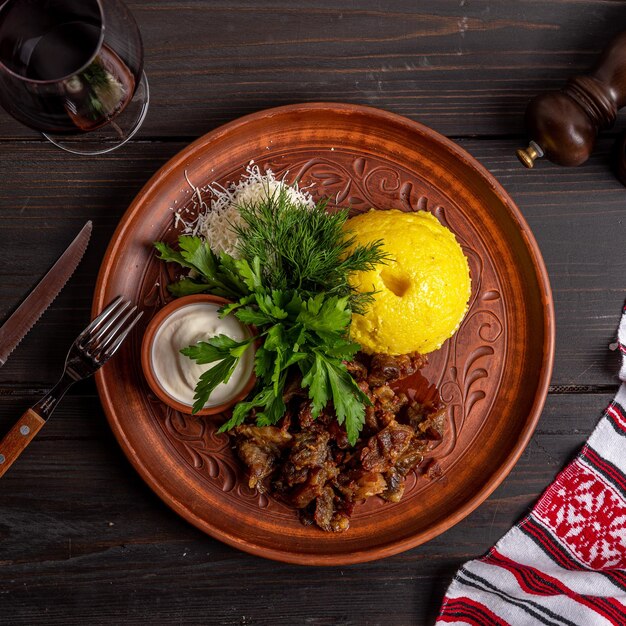 Une assiette de nourriture avec une serviette rouge et blanche et un couteau sur le côté.