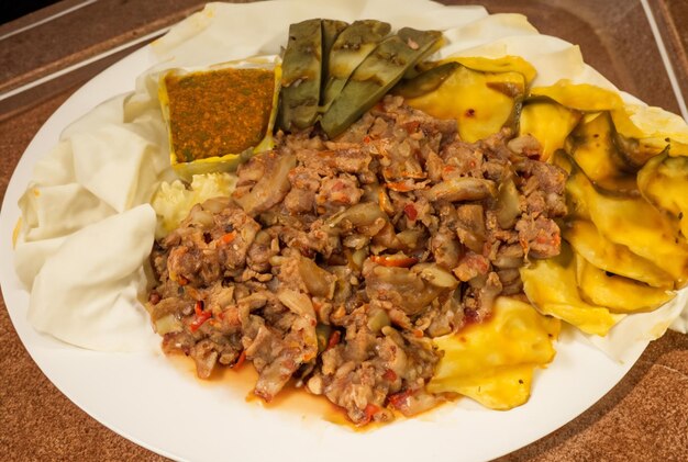 Une assiette de nourriture avec une variété d'ingrédients, y compris de la viande, du fromage et des légumes.